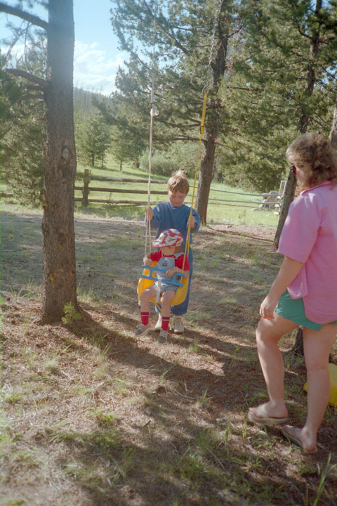 Brian pushing Alex (3) in the swing while Linda looks on